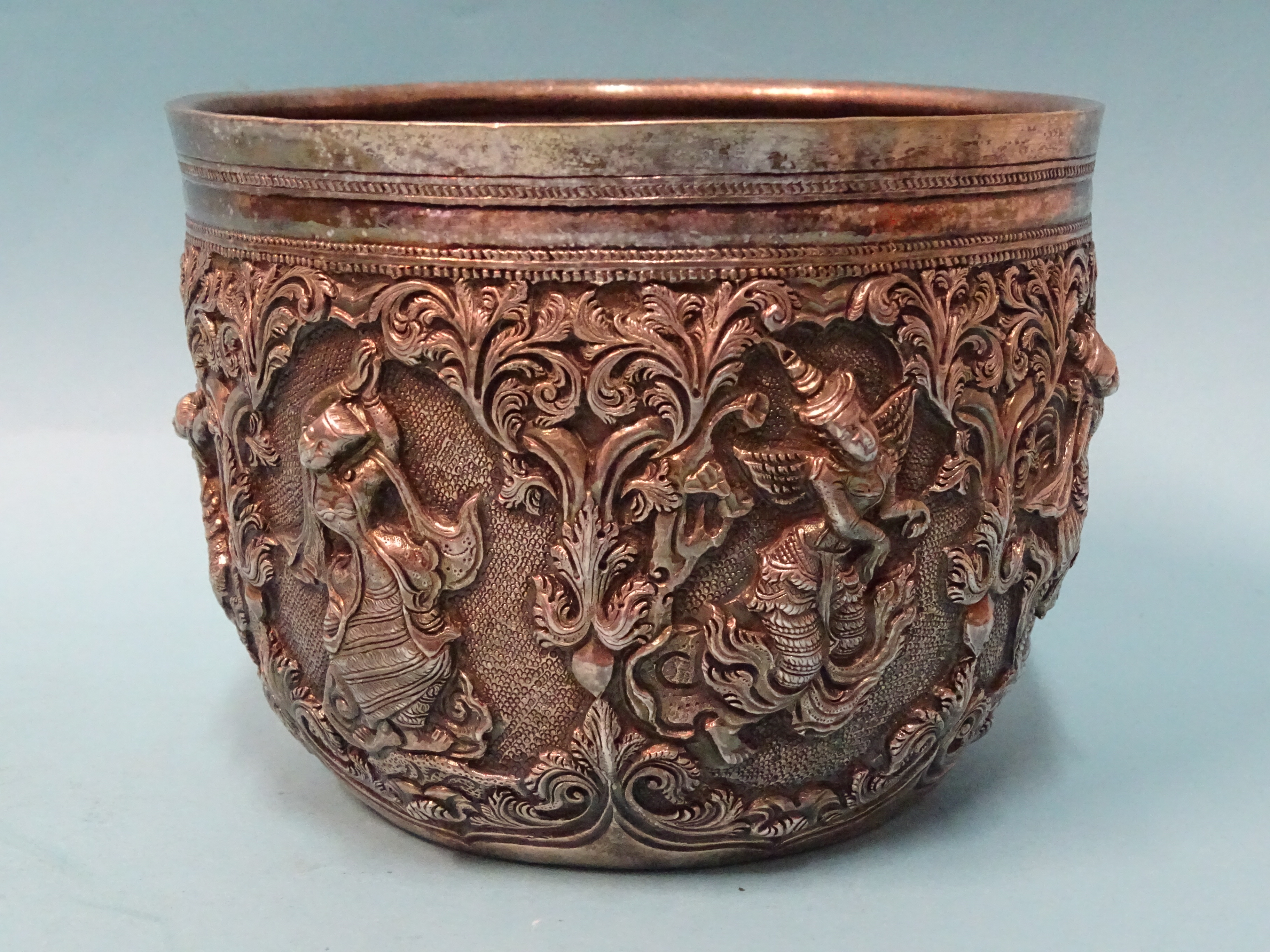 A Burmese silver bowl deeply embossed with deities within scrolling arches, 12.5cm diameter, 9.5cm - Bild 3 aus 5