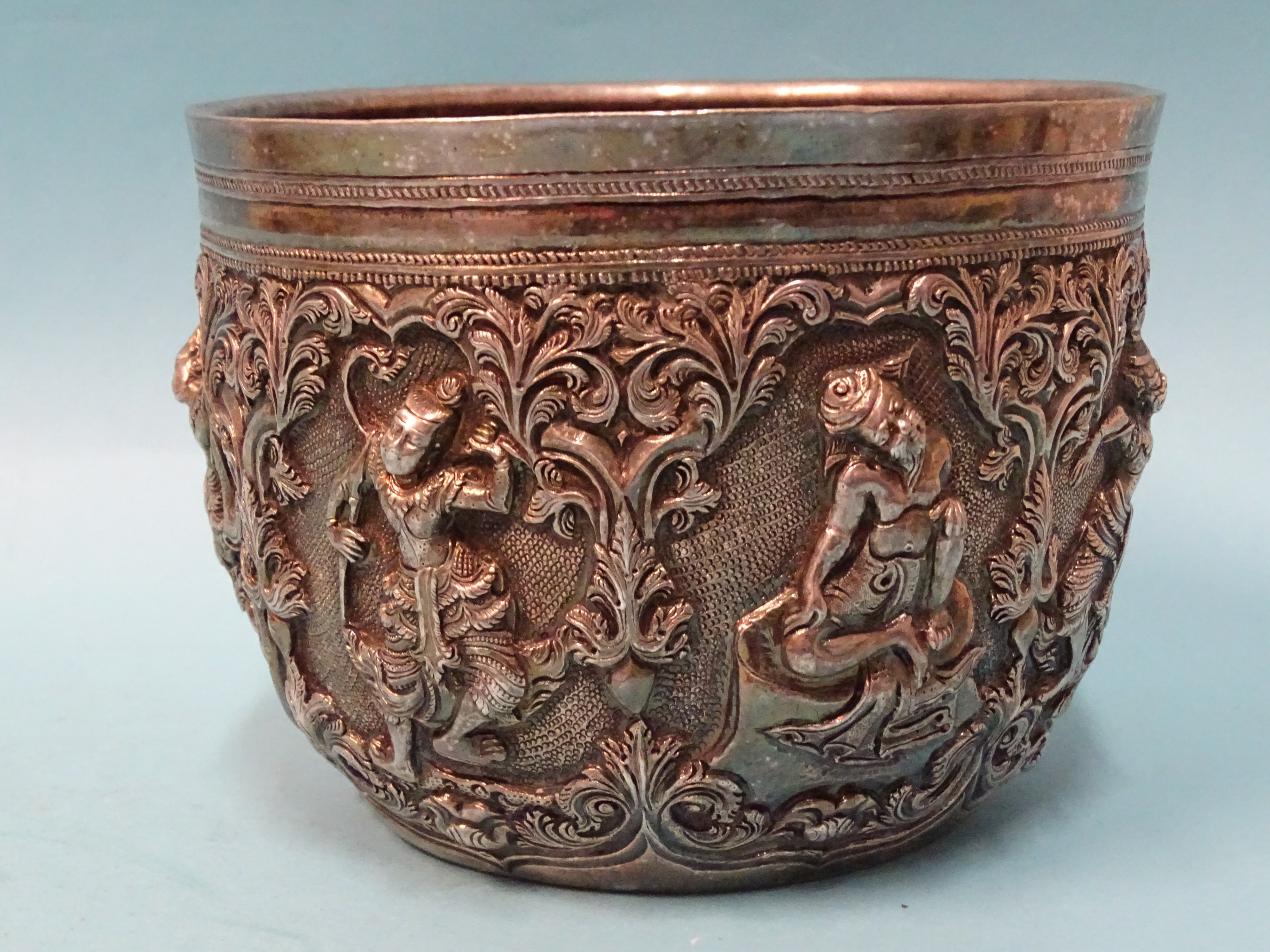 A Burmese silver bowl deeply embossed with deities within scrolling arches, 12.5cm diameter, 9.5cm - Bild 4 aus 5