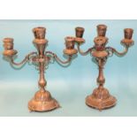 A pair of Egyptian silver three-branch candelabra with baluster stems and domed bases, on three claw