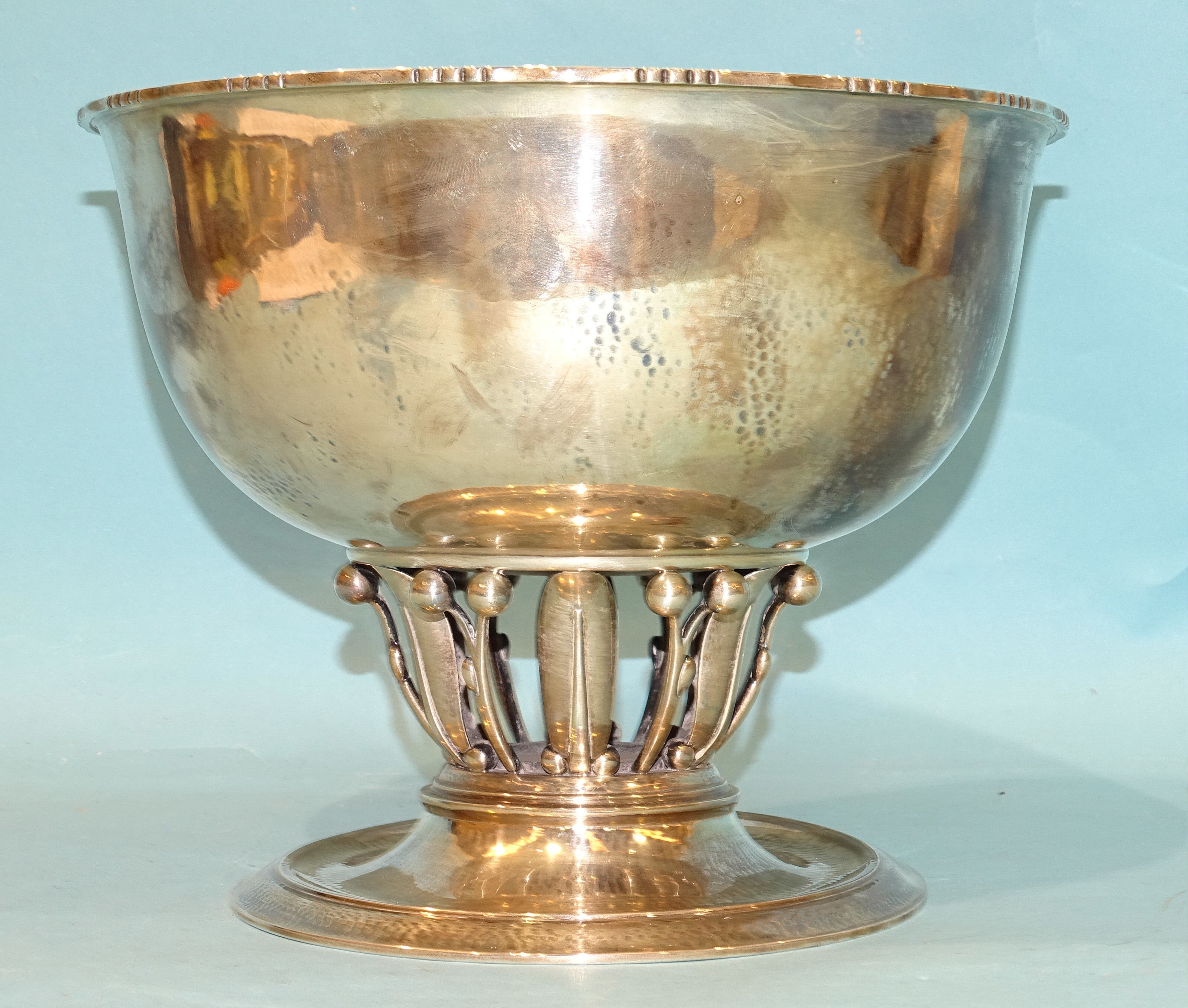 A Georg Jensen beaten silver pedestal bowl, the circular bowl raised on leaf and berry supports,