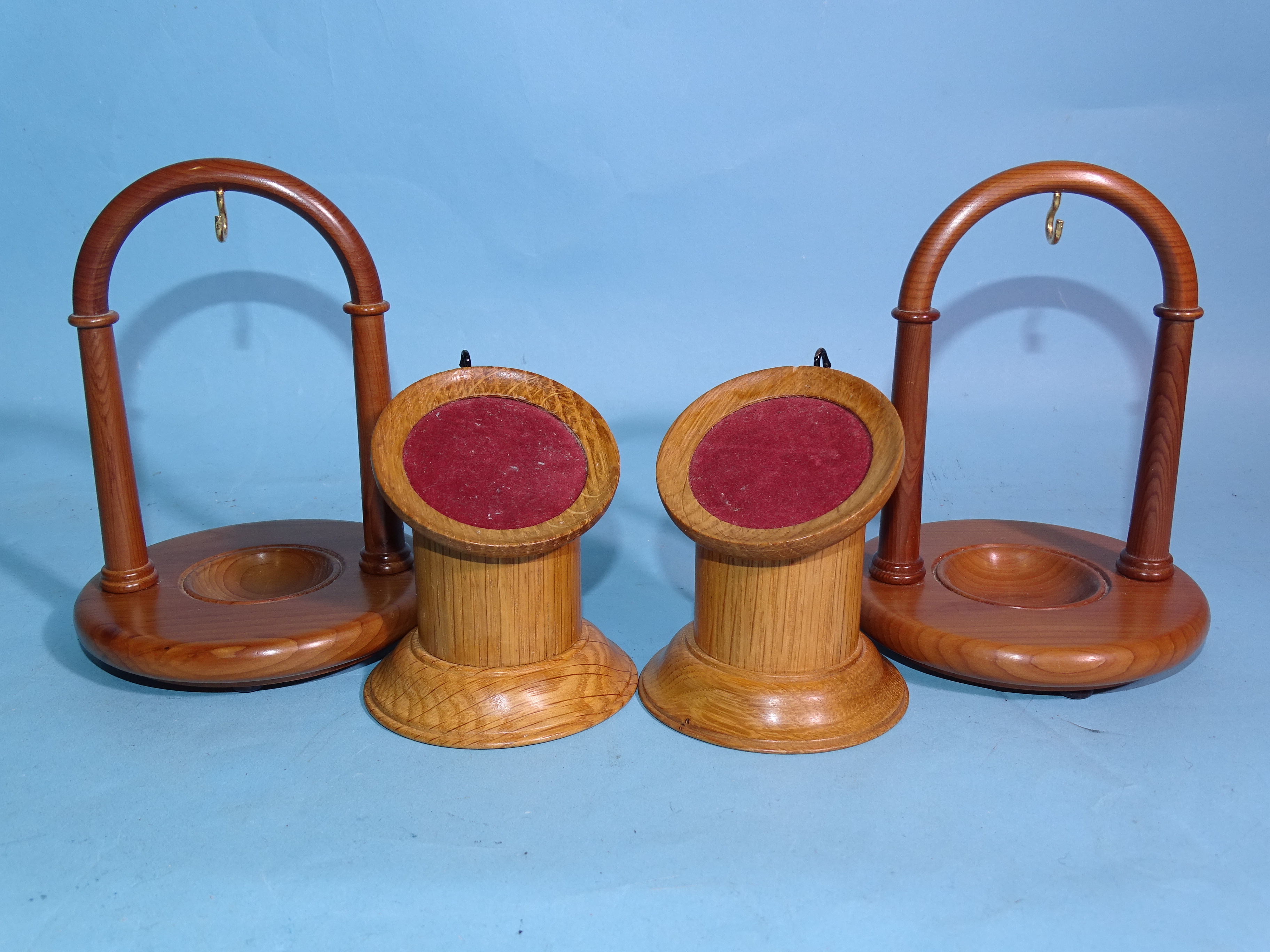 Two modern yew wood arched watch stands, 13.5cm high and two oak pillar watch stands, (4).