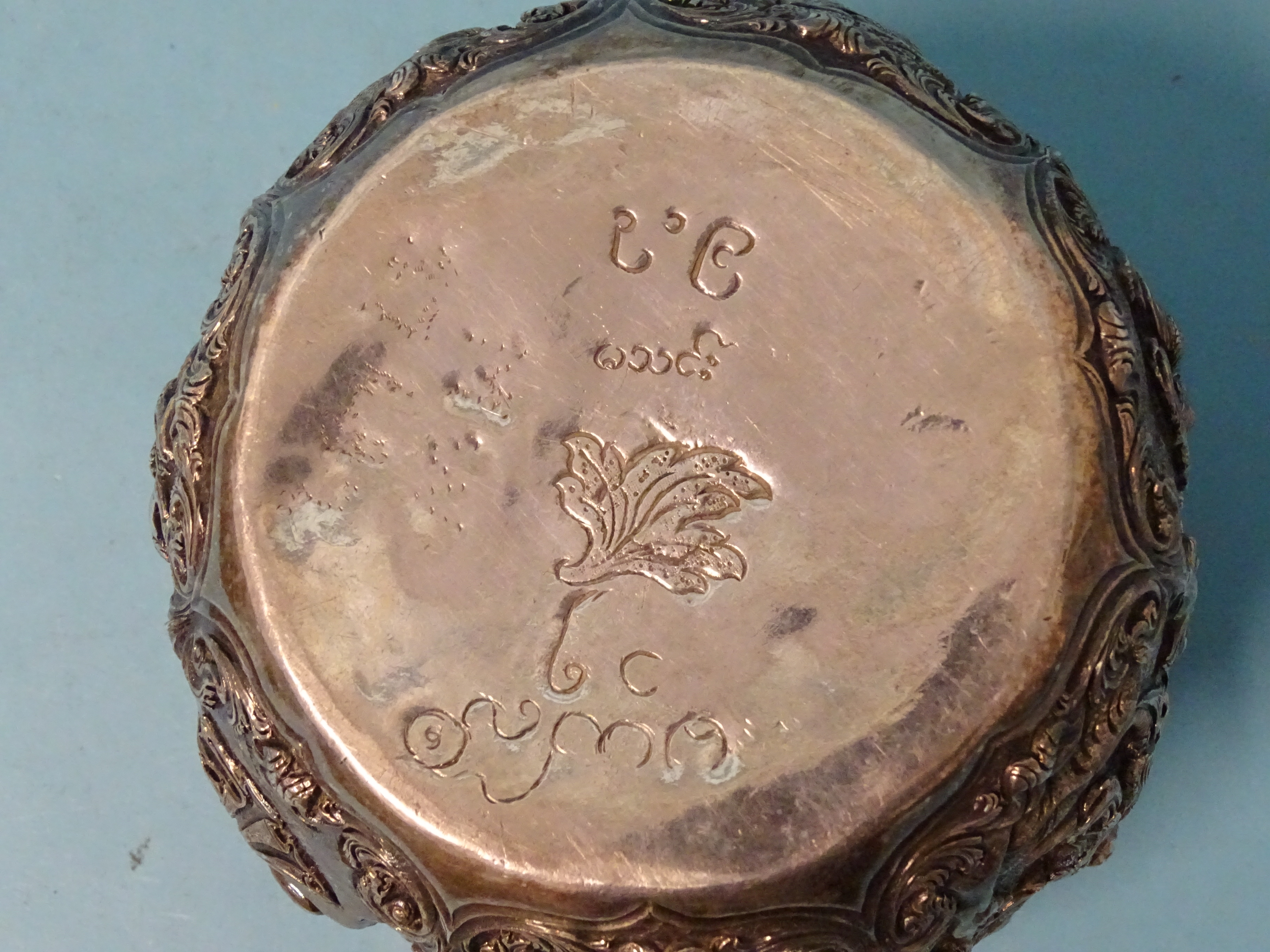 A Burmese silver bowl deeply embossed with deities within scrolling arches, 12.5cm diameter, 9.5cm - Bild 5 aus 5
