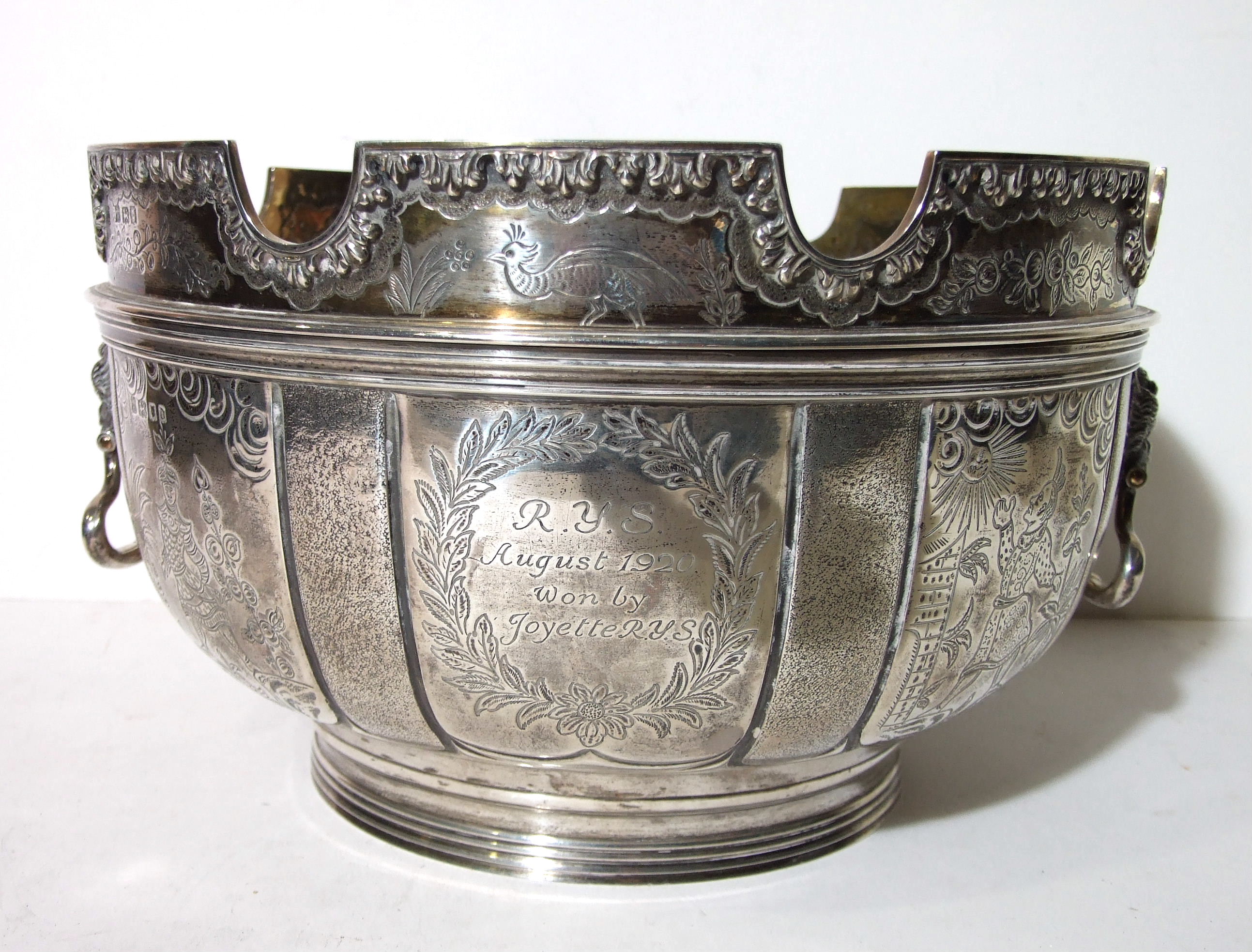 A large silver two-handled punch bowl of circular form on ribbed foot, with five panels in the