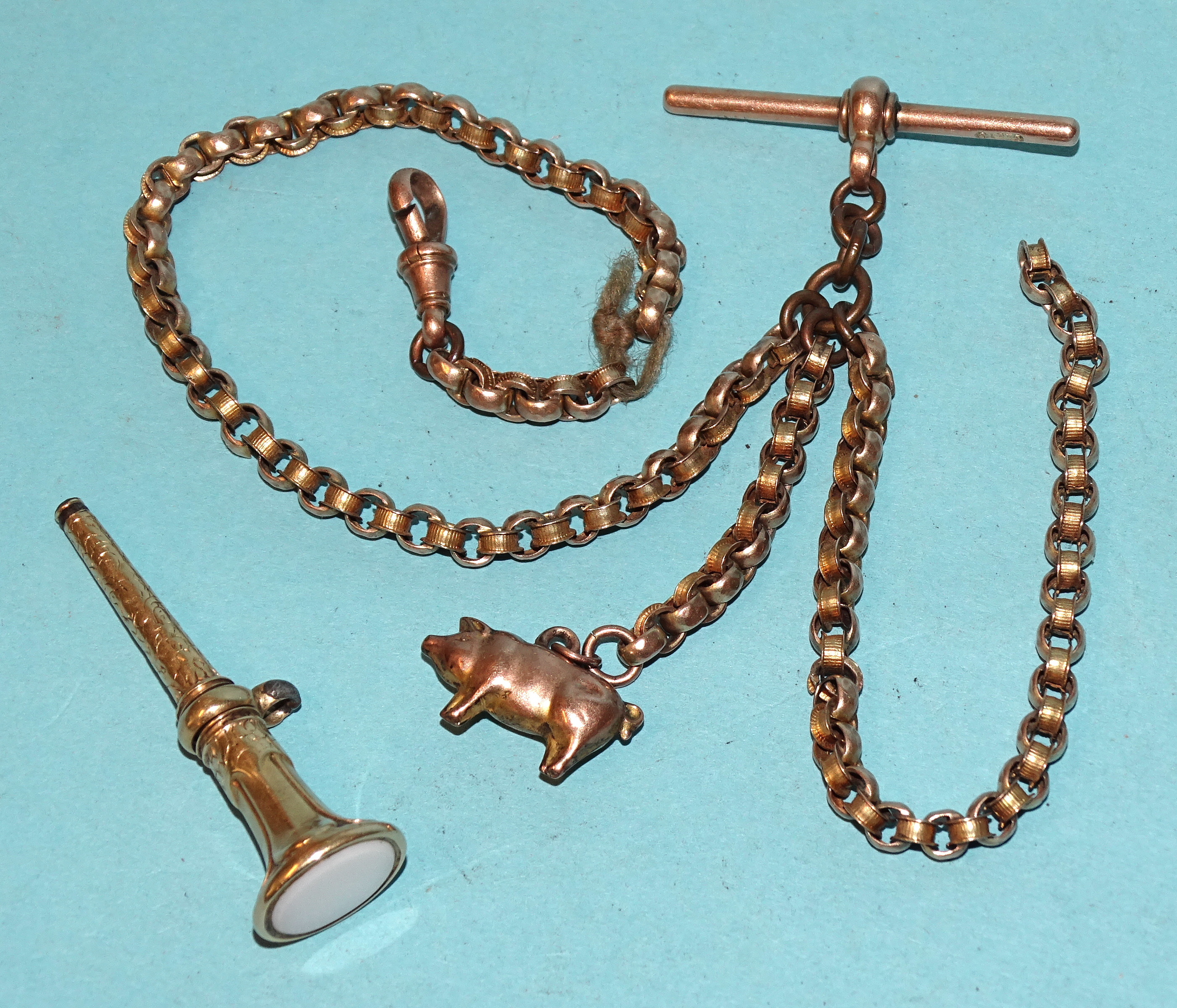A length of Victorian gold watch chain with a T-bar, marked 9ct, a shackle and a pig charm, gross