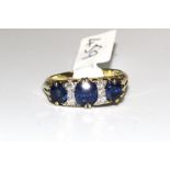 A sapphire and diamond ring set three sapphires with trios of diamonds between, in unmarked gold