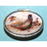 A modern oval pill box, the lid inset an enamelled image of a cock and hen pheasant, 4cm long, (