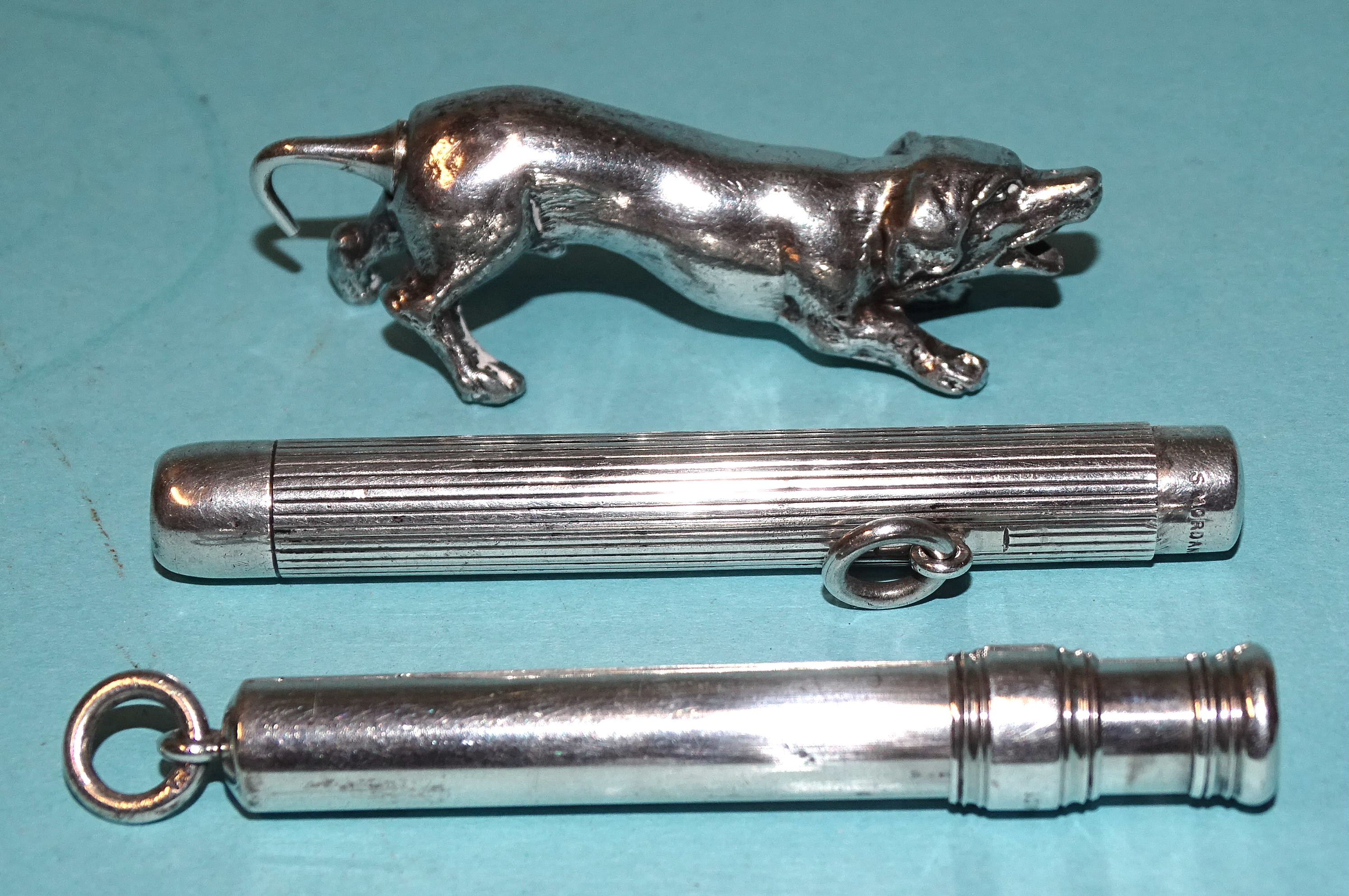 A Sampson Mordan silver sliding pencil holder, another with button mechanism, (a/f) and a white