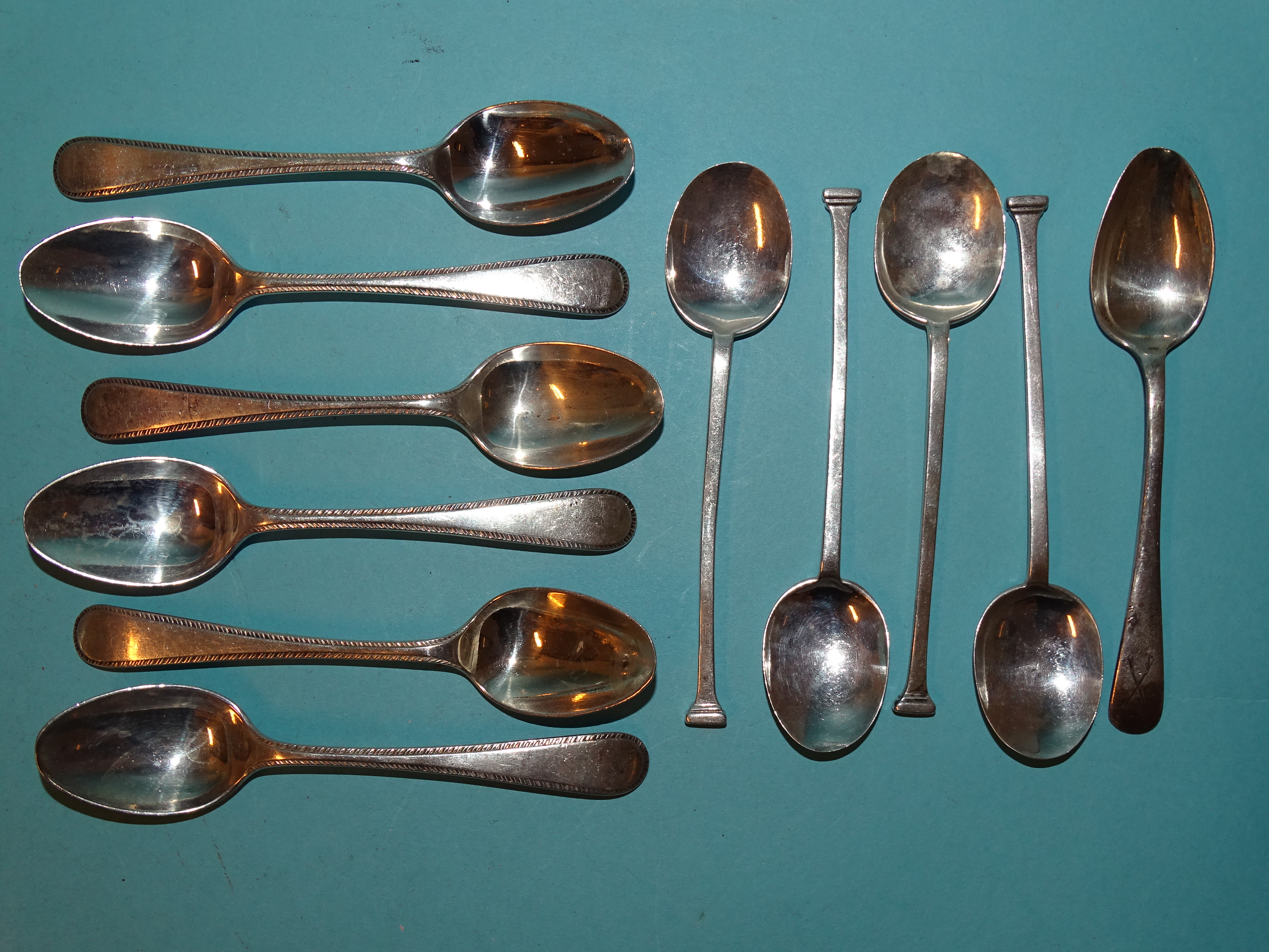 A set of six silver feather-edged teaspoons, Birmingham 1925 and five other silver teaspoons,