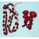 A necklace of graduated cherry amber-type Bakelite beads, (needs restringing), largest bead 32 x