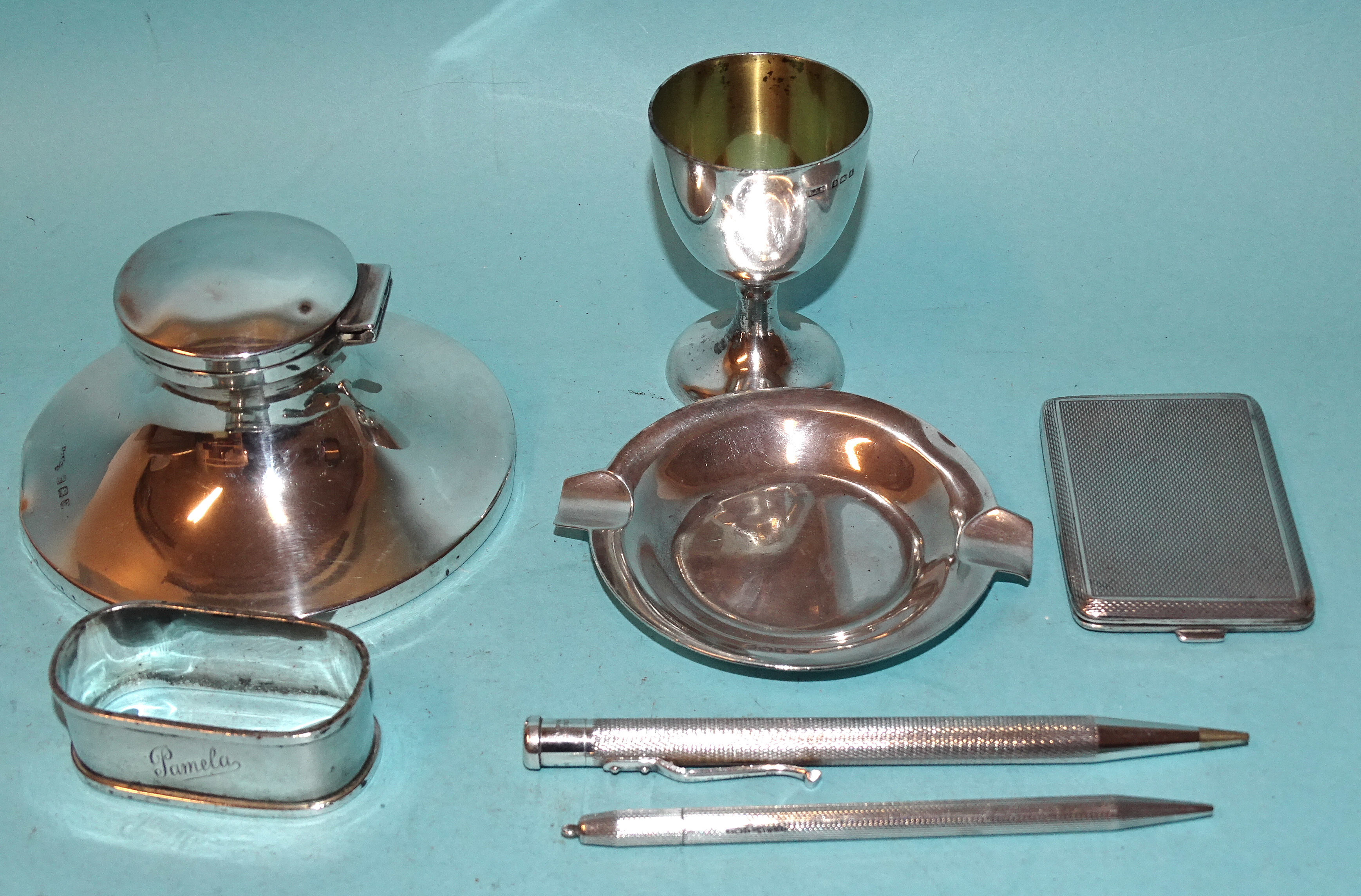 A silver capstan inkwell, (dented), 9.5cm diameter, Birmingham 192*, a silver egg cup, Birmingham