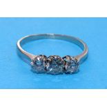 A three-stone diamond ring claw-set old brilliant-cut diamonds, in unmarked white metal ring, (tests