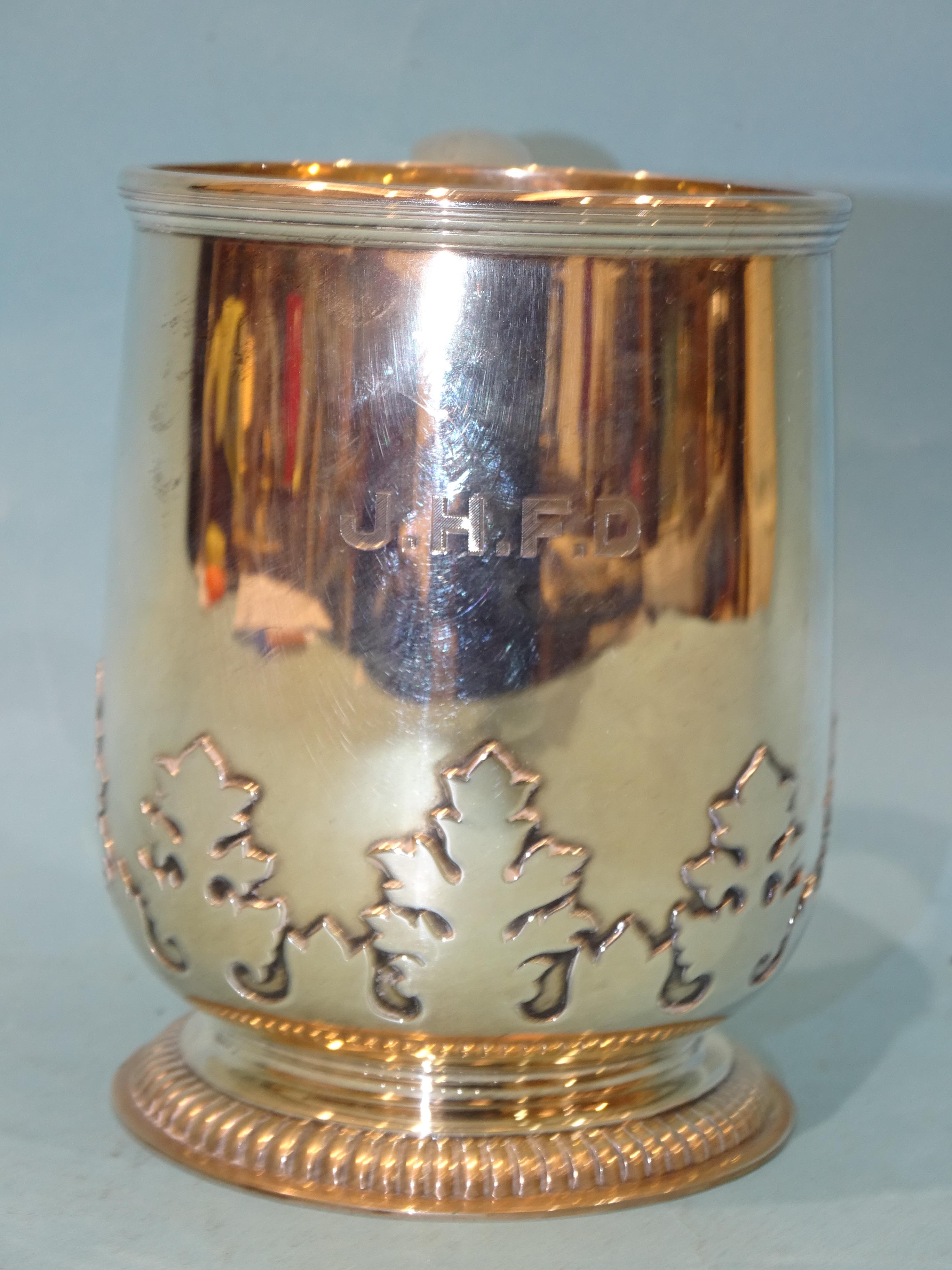 A silver tankard with applied leaf frieze and scroll handle, raised on gadrooned foot, Asprey & - Bild 2 aus 4