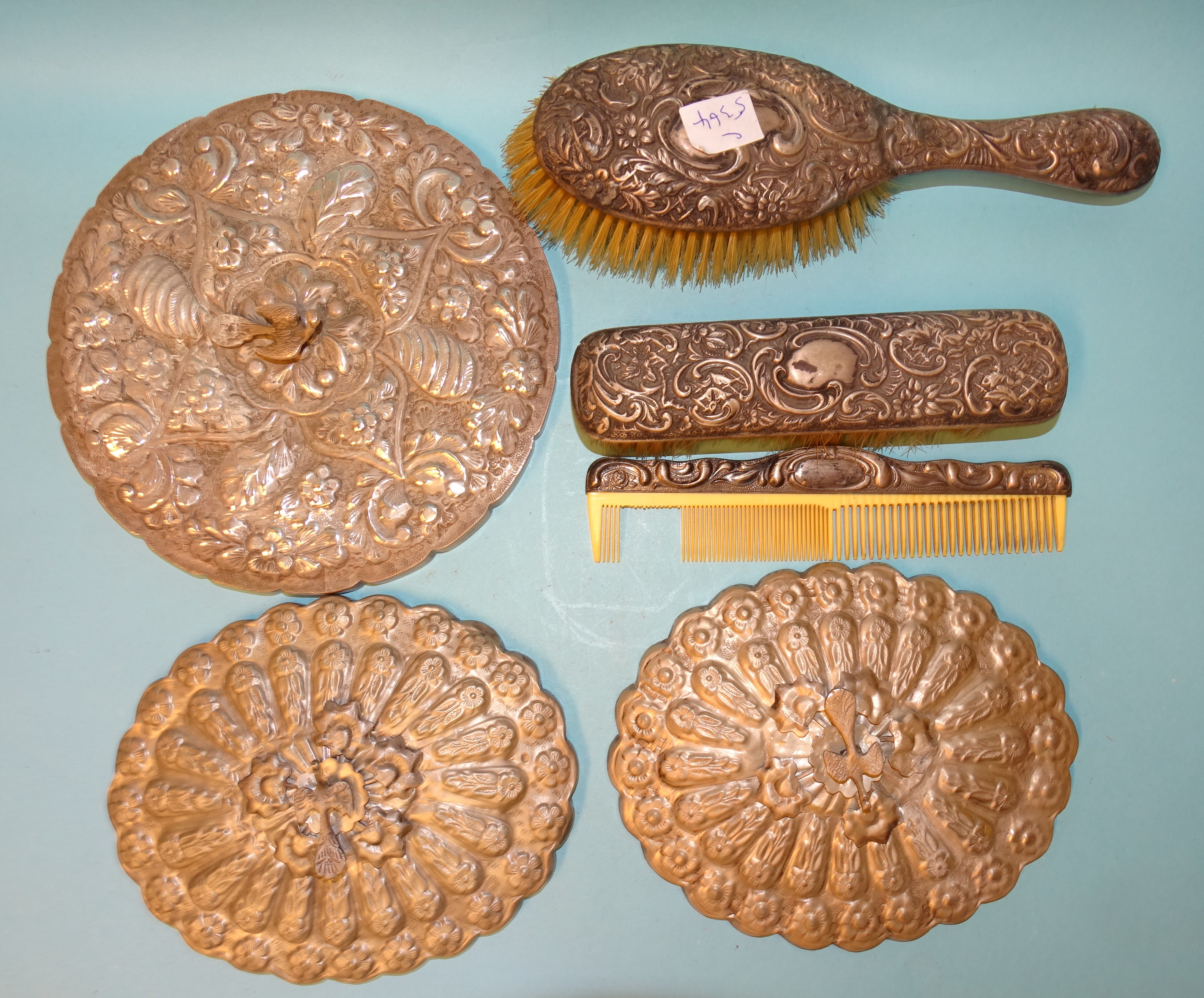 An Egyptian silver circular dressing table mirror surmounted by a peacock, 20cm, two others, similar