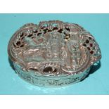 A silver pot pourri box of oval form, the lid pierced and embossed with a scene of figures waving to