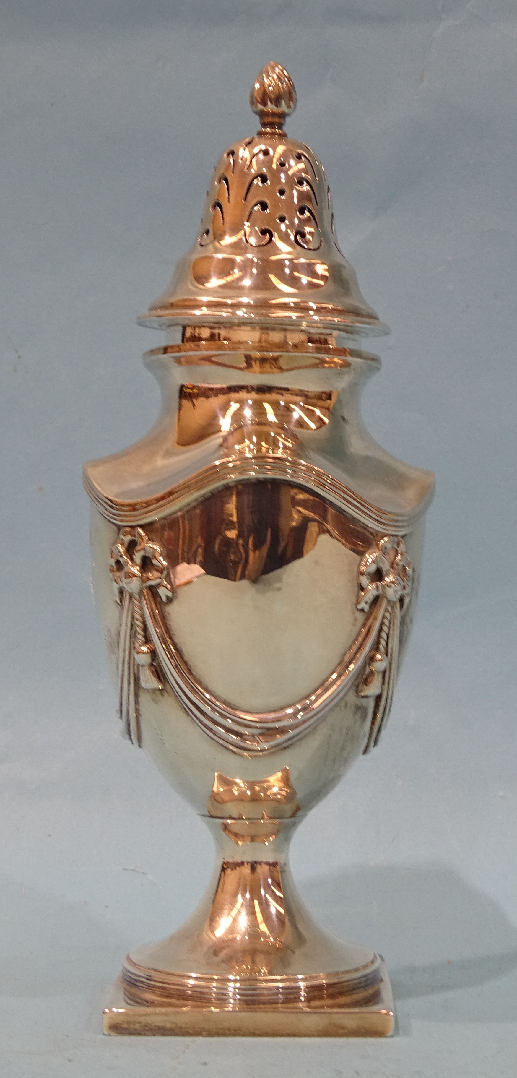 A silver sugar sifter of urn form with applied swag and tassel decoration, raised on square foot, - Bild 2 aus 3