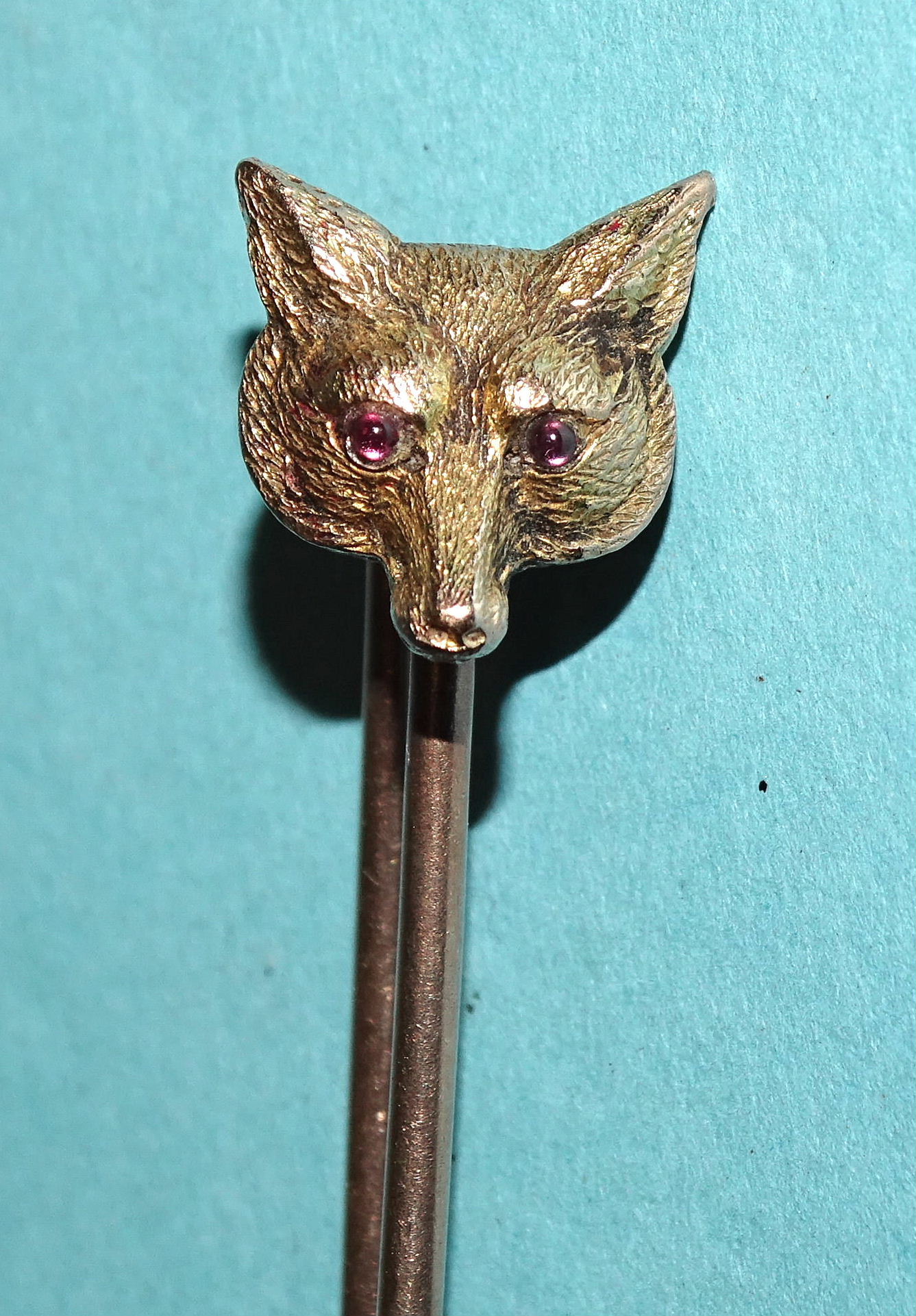 A large 9ct gold brooch surmounted by a fox's mask, with inset red glass eyes, 74mm long, 7.5g.