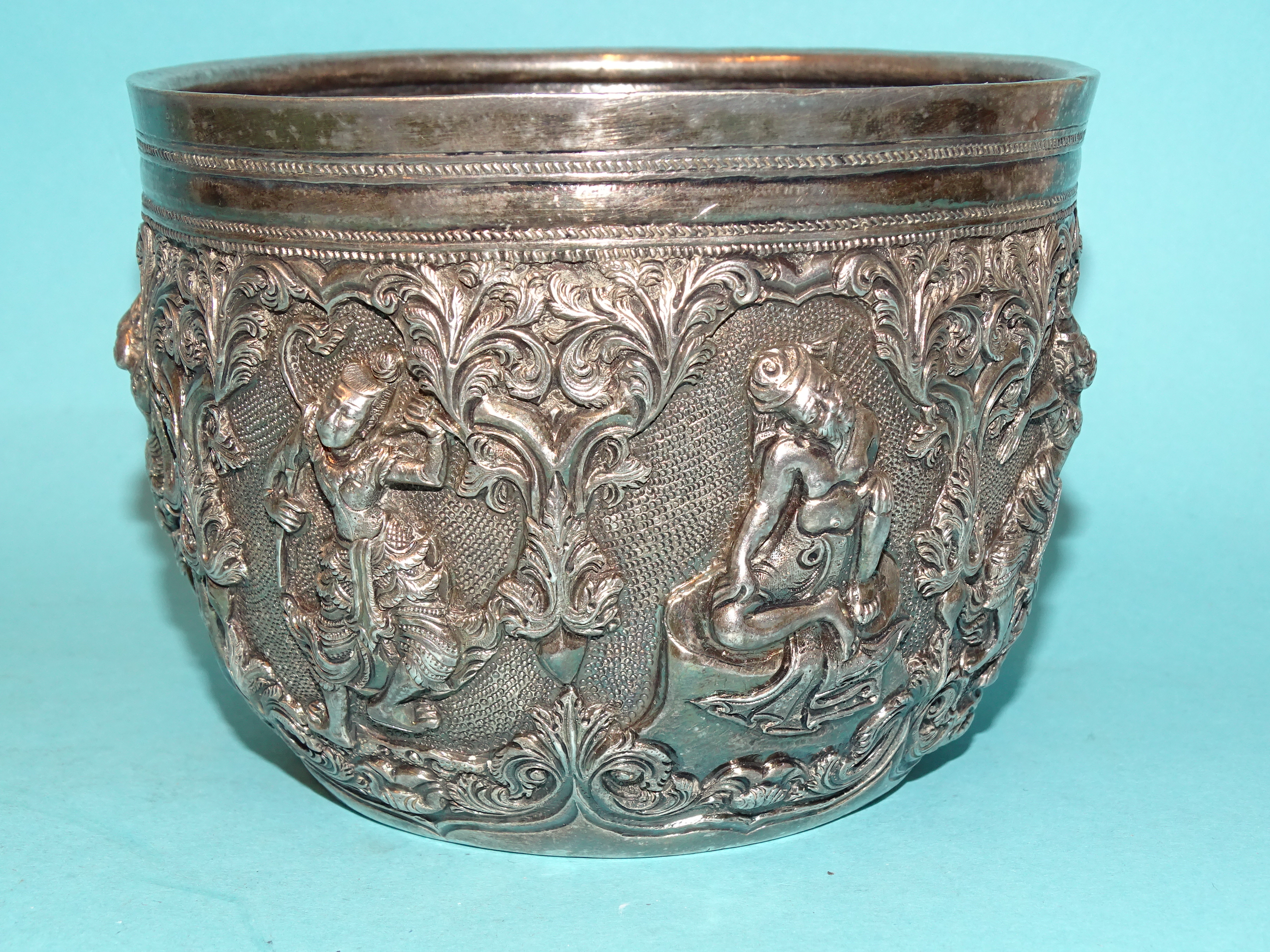 A Burmese silver bowl deeply embossed with deities within scrolling arches, 12.5cm diameter, 9.5cm - Bild 2 aus 5