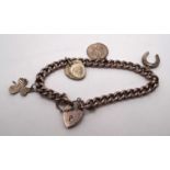 A 9ct rose gold curb-link bracelet with padlock clasp and four charms, (one not marked as 9ct gold),