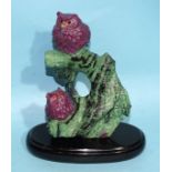 A ruby and zoisite crystal carving of two sitting ruby baby owls perched on the integrated zoisite