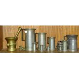 A collection of cylindrical and other pewter measures and a bronze pestle and mortar.