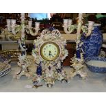 A 20th century ceramic clock set, comprising a clock with applied figures, cherubs and floral