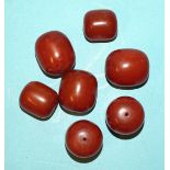 Seven large barrel-shaped butterscotch amber beads, largest 32 x 28mm, 122g.