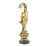 Art Nouveau cast gilt metal and ivoreen figure of a young girl with a basket of fruit at her feet,