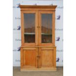 20th century pine cabinet with glazed section over panelled cupboard doors on plinth base,