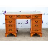 Modern yew veneered pedestal desk of nine drawer configuration on bracket feet, h77 x w123 x d61cm,