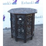 Kashmir carved wooden folding table, the octagonal top carved with vines, on a folding base with