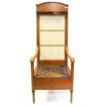 Edwardian quarter veneered satinwood commode chair with high cane back with hinged shelf over a