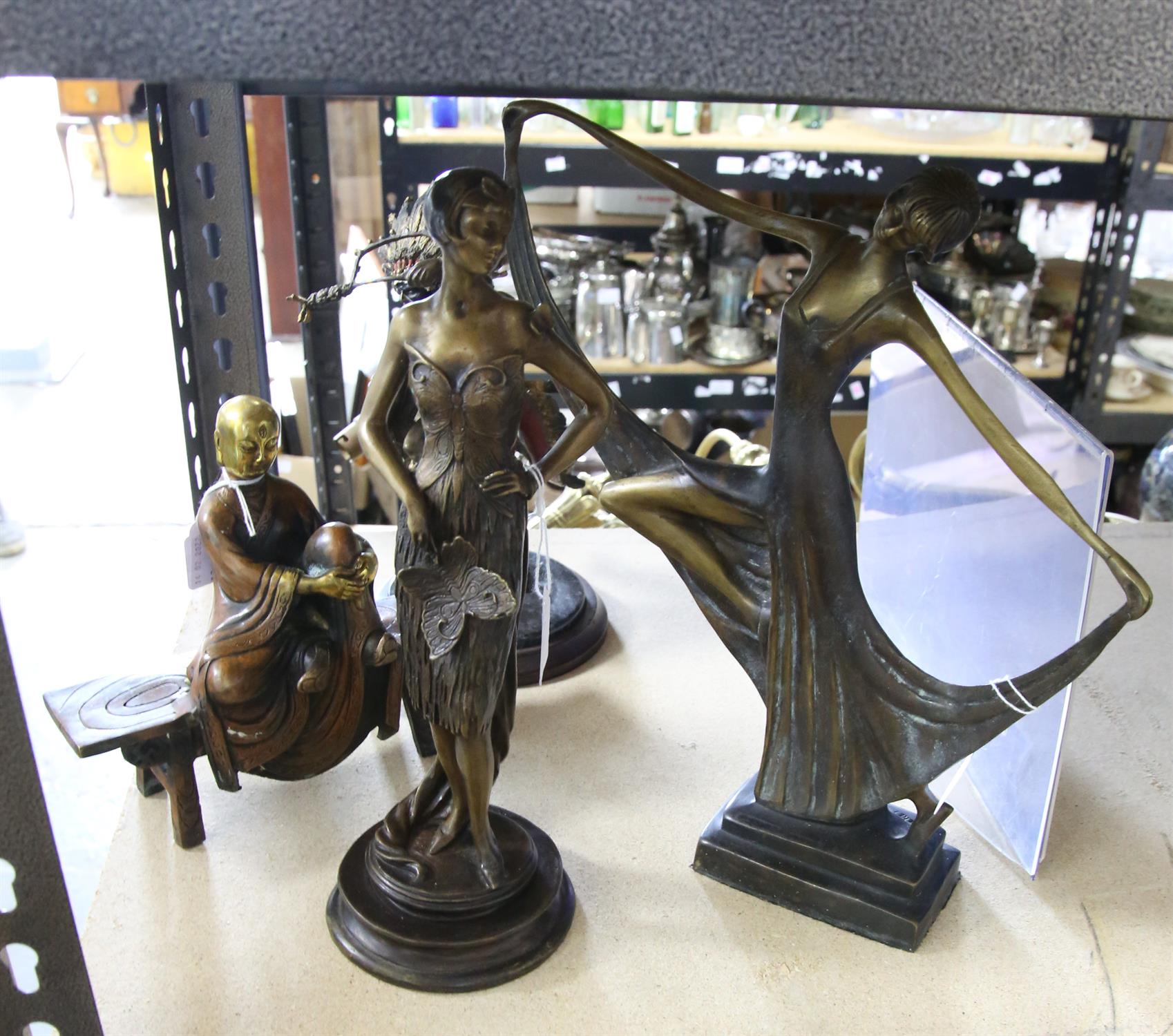 Two cast metal figures of Art Deco women, Native American, and oriental figure on a bench.