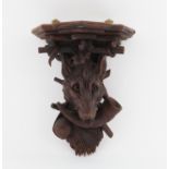 Late 19th/early 20th century, shelf bracket carved with a wolf's head hunting horn branches and