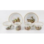 Two Spode trios, with two cups and a saucer, each painted with a landscape and gilt rims,