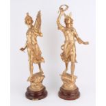 Pair of French metal gilt statues in the form of classical figures on circular plinths,