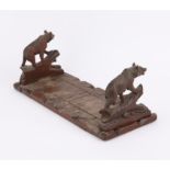 Late 19c Black Forest extending book stand, the hinged extending book ends carved as bears,
