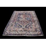 Turkoman rug, with brown twin pole medallion on a blue field, within a multiple serrated border,