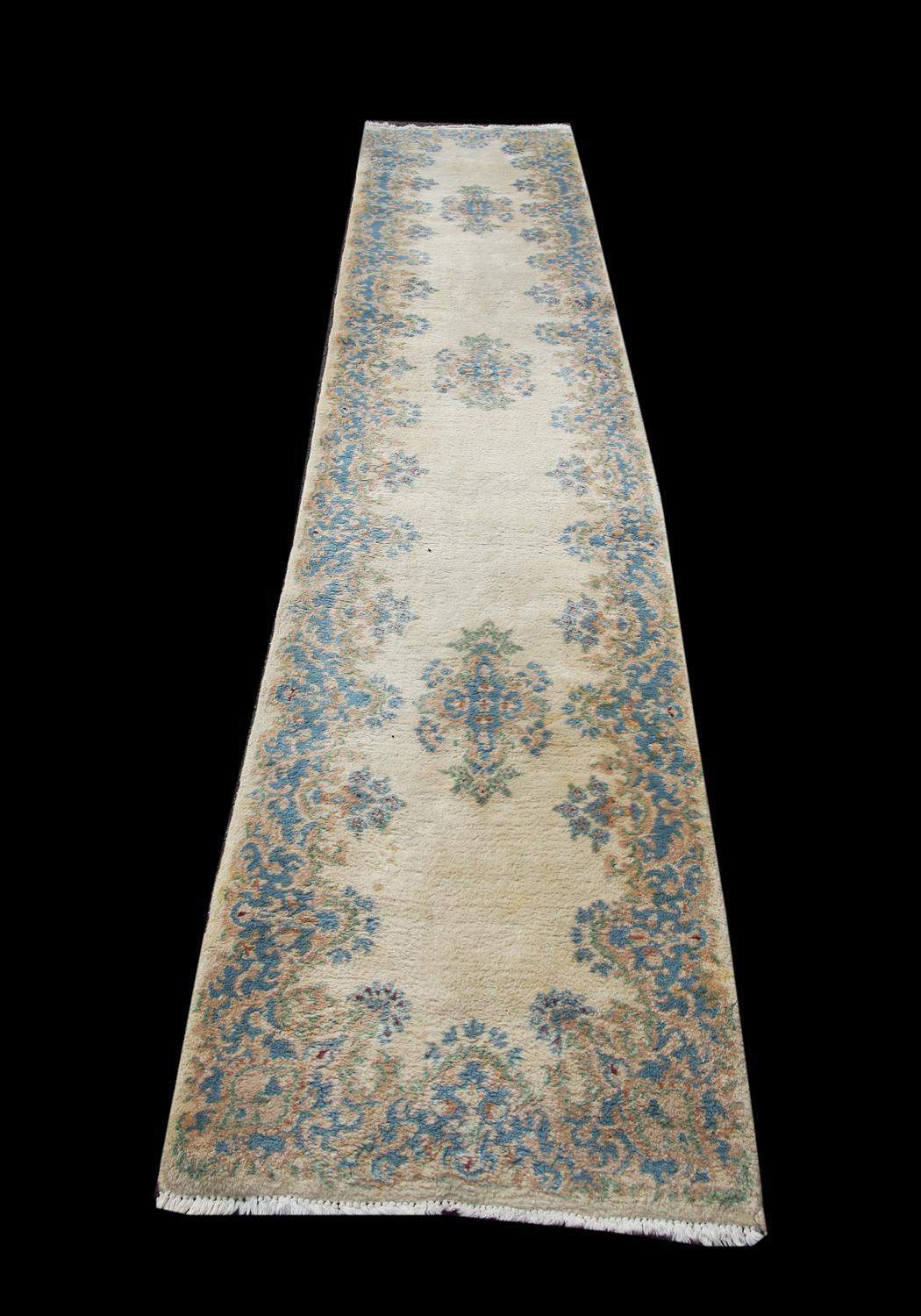 Kerman runner, the blue foliate medallions and border on an ivory field, 371 x 75 cm