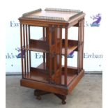 Early 20th century mahogany revolving bookcase, with gilt brass baluster gallery top and two tiers,