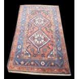 Turkoman rug, with ivory twin pole medallion on a red field with blue serrated leaf border,
