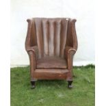 Leather tub shape wing armchair, on cabriole legs and castors, H107 cm