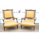 Pair of late Victorian rosewood fire side armchairs, the square padded backs and arms on scroll