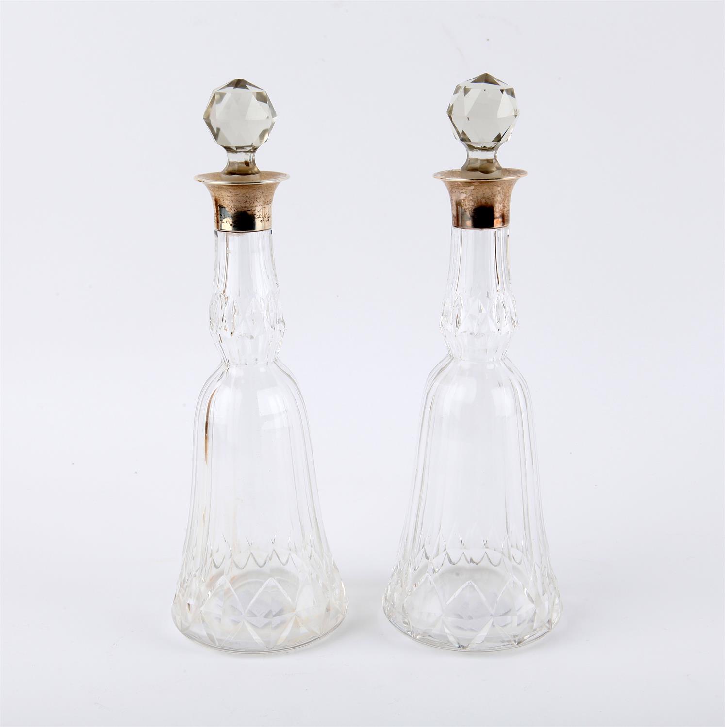 Pair of cut glass bottles and stoppers, with silver collars, London 1924 Mappin & Webb,