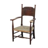 Arts & Crafts open armchair, with broad top rail and scroll arms, over a rush seat on turned