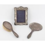 Silver backed mirror and brush and a silver photo frame
