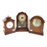 Early 20th century chequer banded mahogany mantel timepiece clock, the arched case with enamel dial