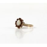Opal and garnet cluster ring, oval cabochon cut opal, with a surround of round cut garnets,