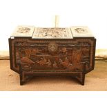 Chinese carved camphorwood chest, the stepped top and sides carved with figures in village scenes,