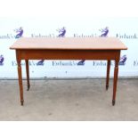 Mahogany side table, with rectangular top on turned tapering legs with brass castors,