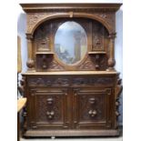 Late 19th century carved oak mirror back sideboard, with mask and fruit panels, the protruding